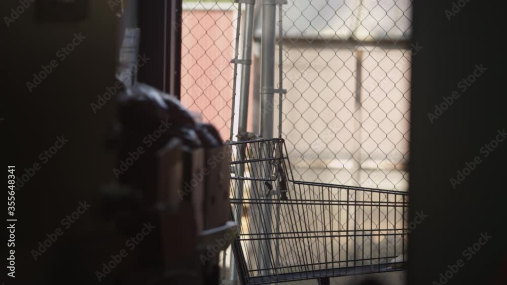 Silhouette rack focus onto a grocery shopping cart outside a volunteer food bank Silhouette rack focus onto a grocery shopping cart outside a volunteer food bank