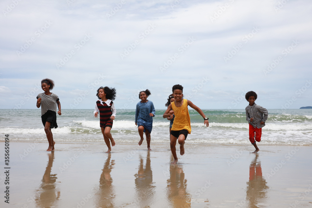 Happy kids running along the seaside , deversity children run playing on beach