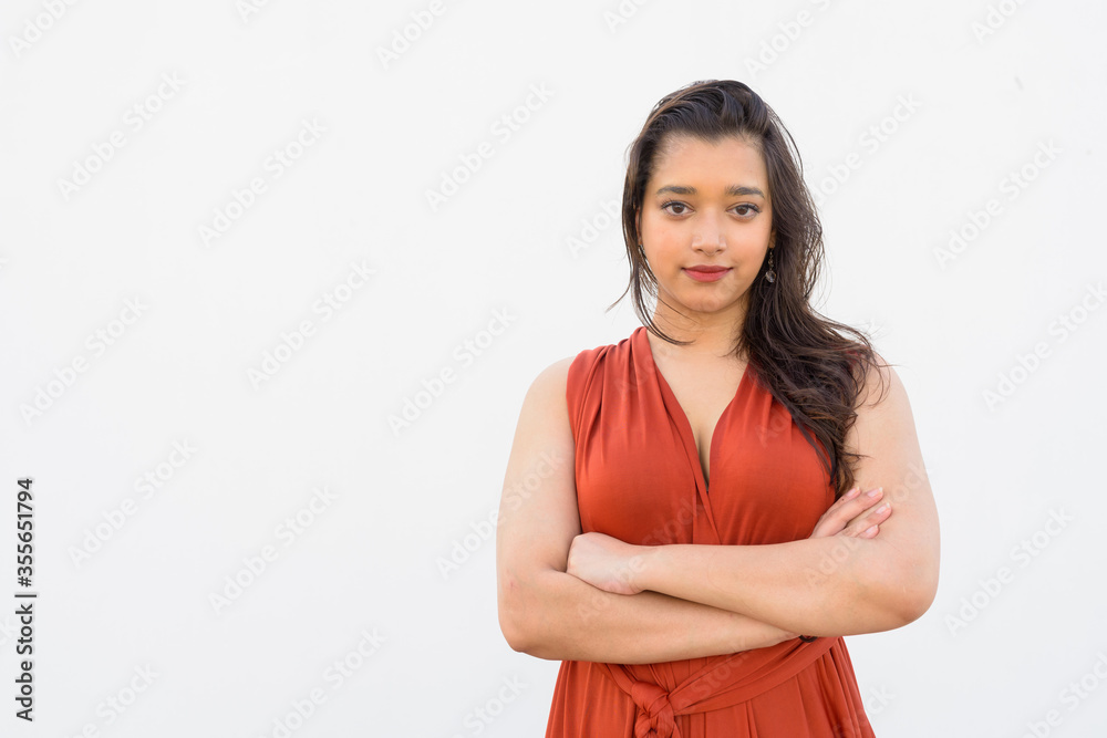 Young beautiful Indian woman with arms crossed against white background Young beautiful Indian woman with arms crossed against white background