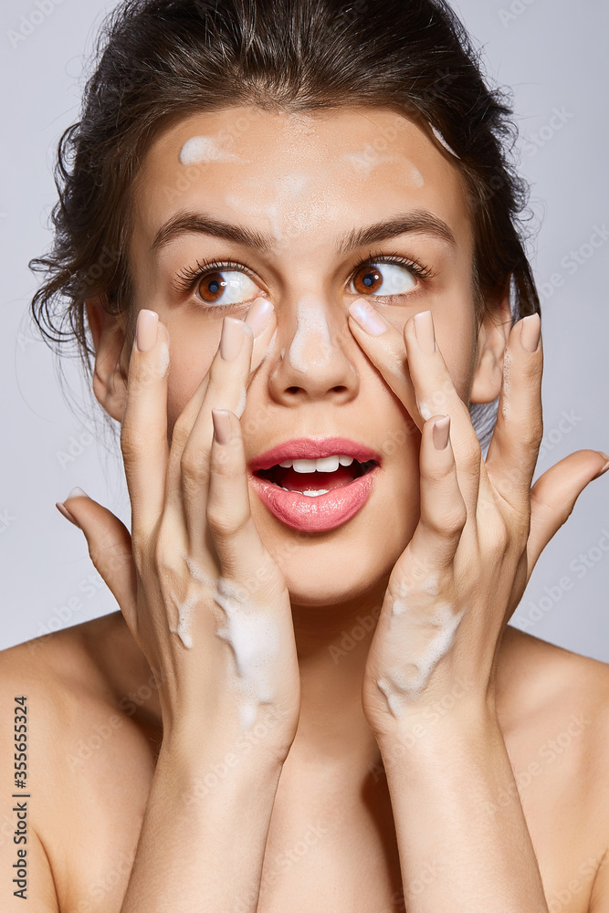 Face masks are the perfect treatment to hydrate skin, remove excess oils and improve the appearance of pores. A young brown-haired lady with glowing skin is applying white bubbling mass on her face. Face masks are the perfect treatment to hydrate skin, remove excess oils and improve the appearance of pores. A young brown-haired lady with glowing skin is applying white bubbling mass on her face.