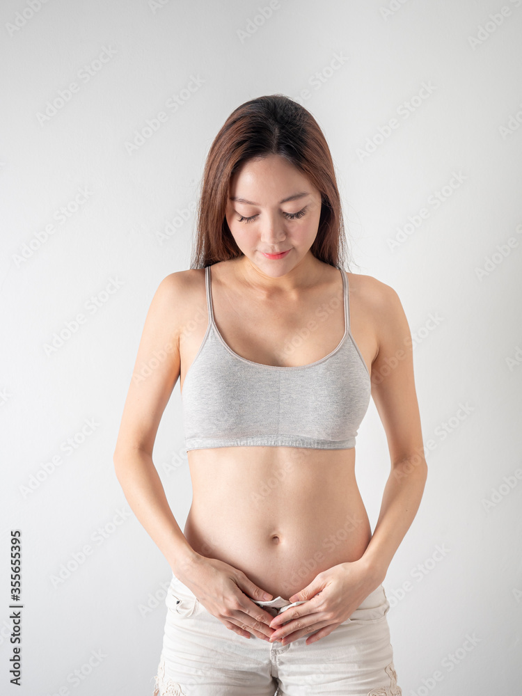 Studio Portrait of 2 months Pregnant Woman on white background. Studio Portrait of 2 months Pregnant Woman on white background.