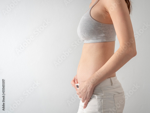 Studio Portrait of 2 months Pregnant Woman on white background.