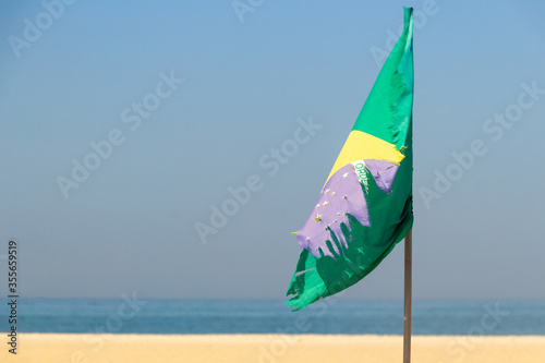 Faded and torn Brazil flag outdoors on Copacabana beach