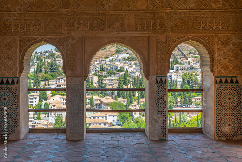 Albaicin district viewed through decorated windows of Torre de las damas at Alhambra palace in Granada, Spain photo