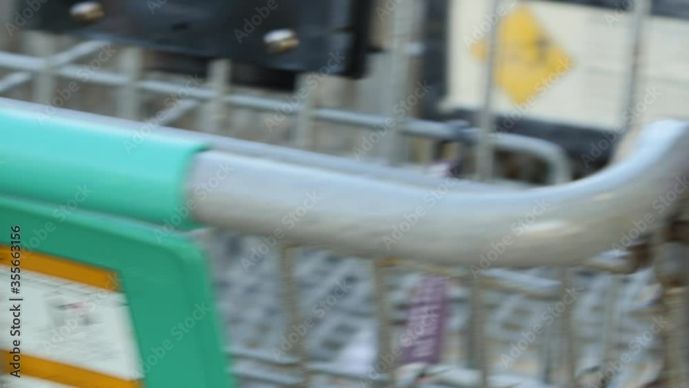 Close-up of hands wiping down and sanitizing a grocery store shopping cart during the COVID-19 pandemic Close-up of hands wiping down and sanitizing a grocery store shopping cart during the COVID-19 pandemic