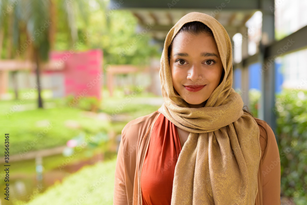 Face of young beautiful Indian Muslim woman at the park outdoors Face of young beautiful Indian Muslim woman at the park outdoors