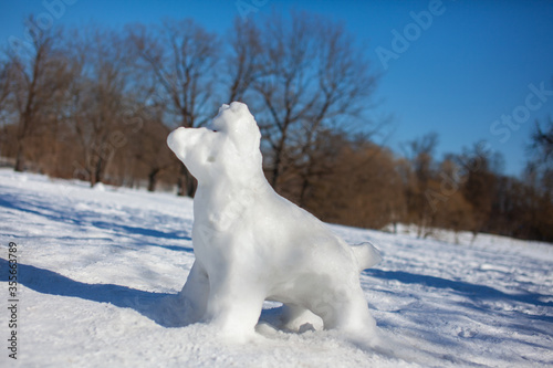 The figure of the white dog cobbled from snow, sculpted snowman in the Park