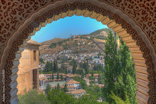 Albaicin district viewed through decorated windows of Nasrid Palace at Alhambra palace in Granada, Spain