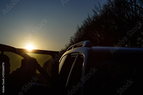 car against the setting sun