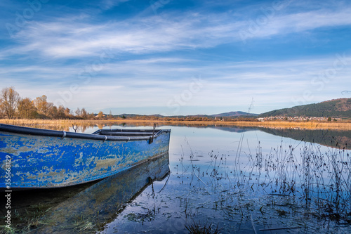 Small blue abandoned fishing boat. Lake Cerknica  one of the largest intermittent lakes in Europe. Low angle  wide shot