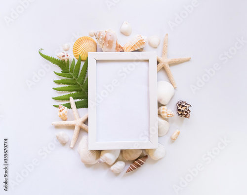 Top view, beach, shell and white picture frame.
