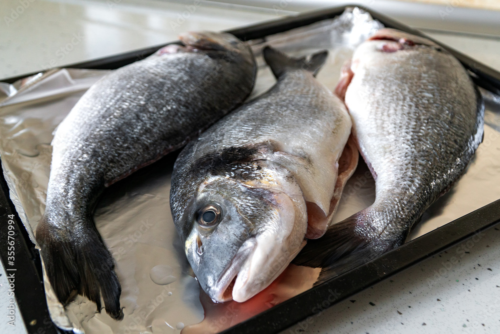 Raw Dorada Fish on a Baking Tray. Cooking fish at home