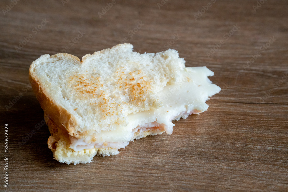 Half Eaten Sandwich thrown on the floor. Discarded Sandwich. Bread tossed to the floor. Thrown into the trash food. Concept.