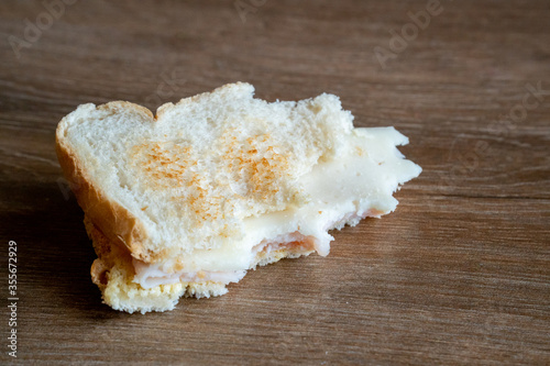 Half Eaten Sandwich thrown on the floor. Discarded Sandwich. Bread tossed to the floor. Thrown into the trash food. Concept.