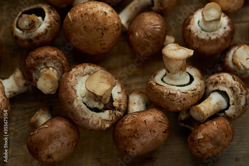 Champignon mushrooms on a wooden board. Fresh healthy brown mushrooms.
