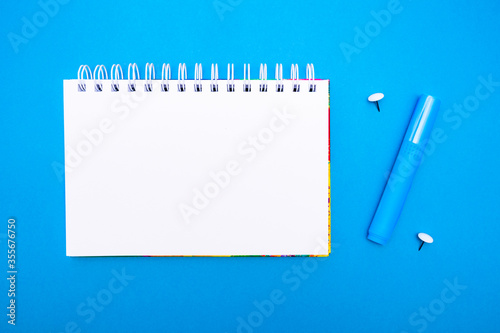 Minimalist school or office concept. top view of notepad and stationery in the form of percent on a blue background with copy space.