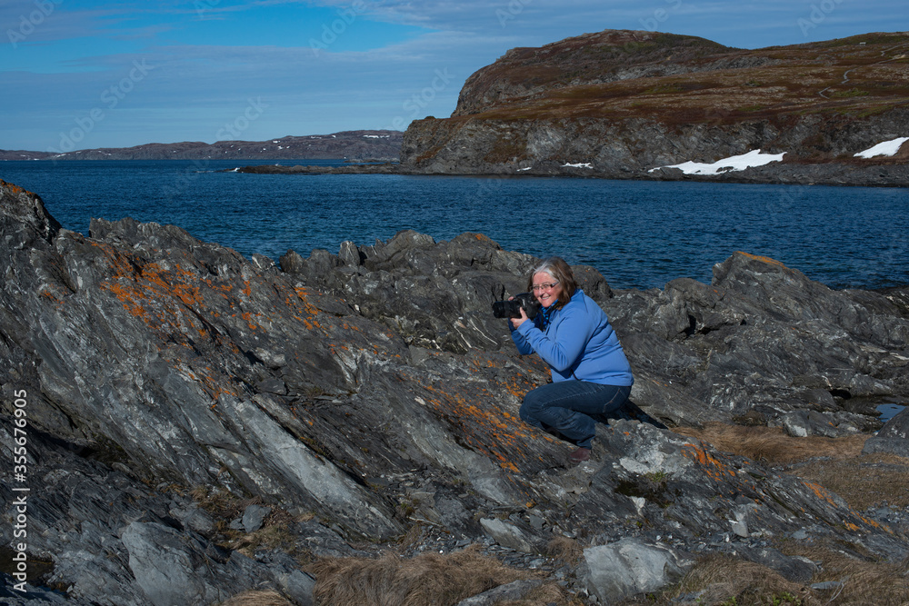 Rocky Beach, woman with camera, blue water and snow. Self Portrait Wendy Nuttall (6/6/2020)