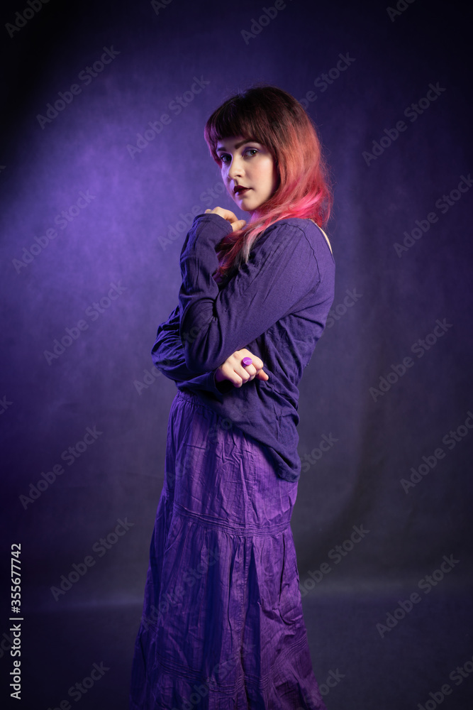 Beautiful girl in studio portrait in violet-blue image. Portrait of young woman in creative image Beautiful girl in studio portrait in violet-blue image. Portrait of young woman in creative image