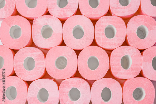 Rolls of pink toilet paper. Abstract background or texture. Large number of rolls of pink toilet paper