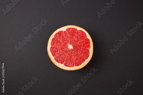 Grapefruit slice isolated on abstract black background