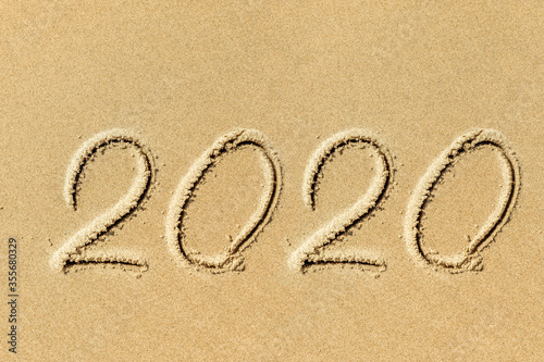 new year 2020 written in sand