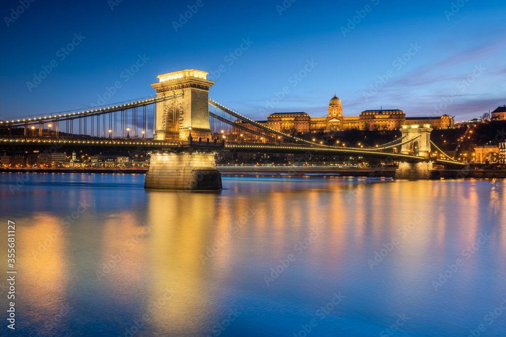 Buda castle with Szechenyi Chain Bridge foreground reflect in Danube river during sunset Buda castle with Szechenyi Chain Bridge foreground reflect in Danube river during sunset