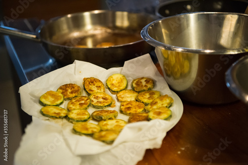 Fried zucchini rings on a tissue soaking oil. Almost ready to serve vegetarian food.