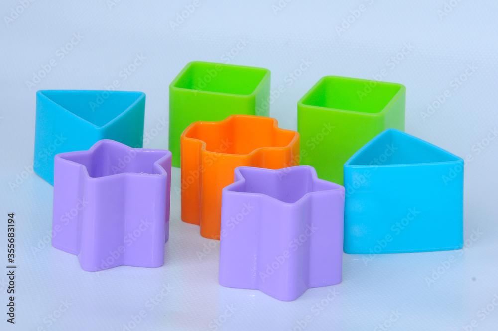 Fototapeta premium Isolated children's toy blocks in various shapes made of plastic on white background 