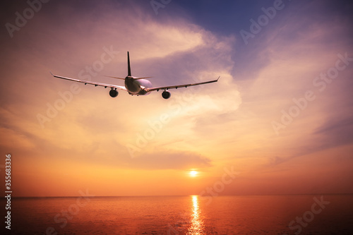 Airplane flying over amazing tropical sunset landscape © PerfectLazybones