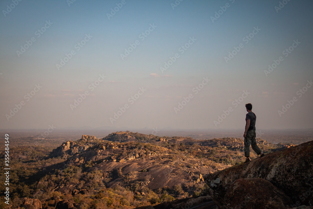 Fototapeta silhouette of a man standing on a mountain top