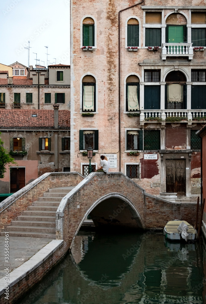 A view of a Venetian canal with traditional townhouses.