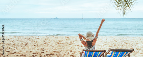 Happy traveler asian woman relax on chair beach in summer Thailand
