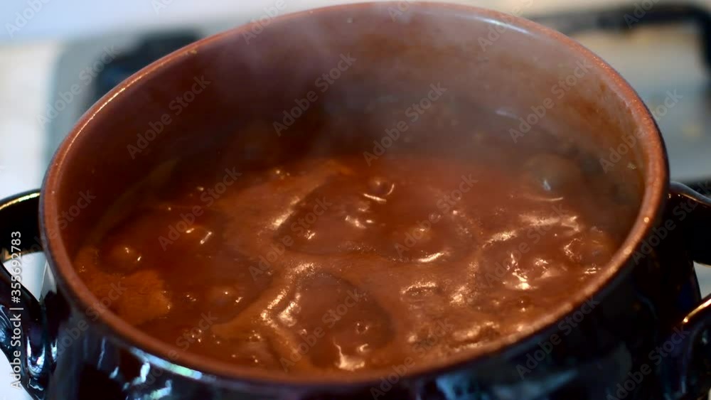 il ragù bolle nella pentola di terracotta