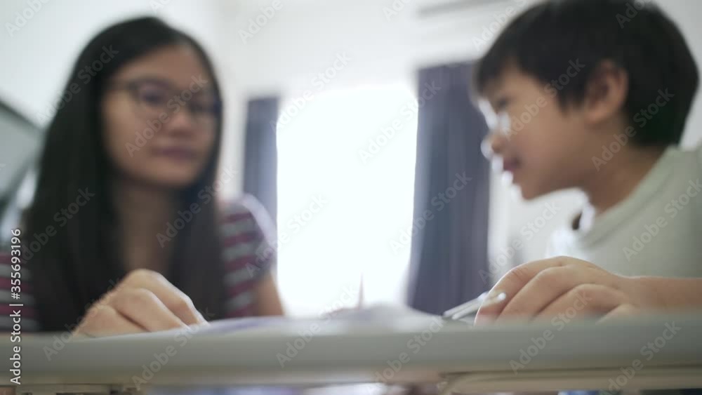 Asian boy about 4 years old drawing picture by color pencil as a home study with his mother Asian boy about 4 years old drawing picture by color pencil as a home study with his mother