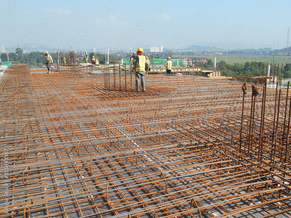 MALACCA, MALAYSIA SEPTEMBER 23, 2016 Construction workers fabricating steel reinforcement bar