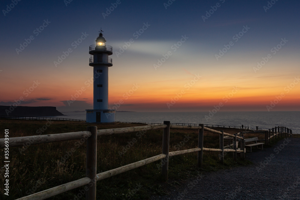 Lighthouse lit at sunset, Cantabria, Spain