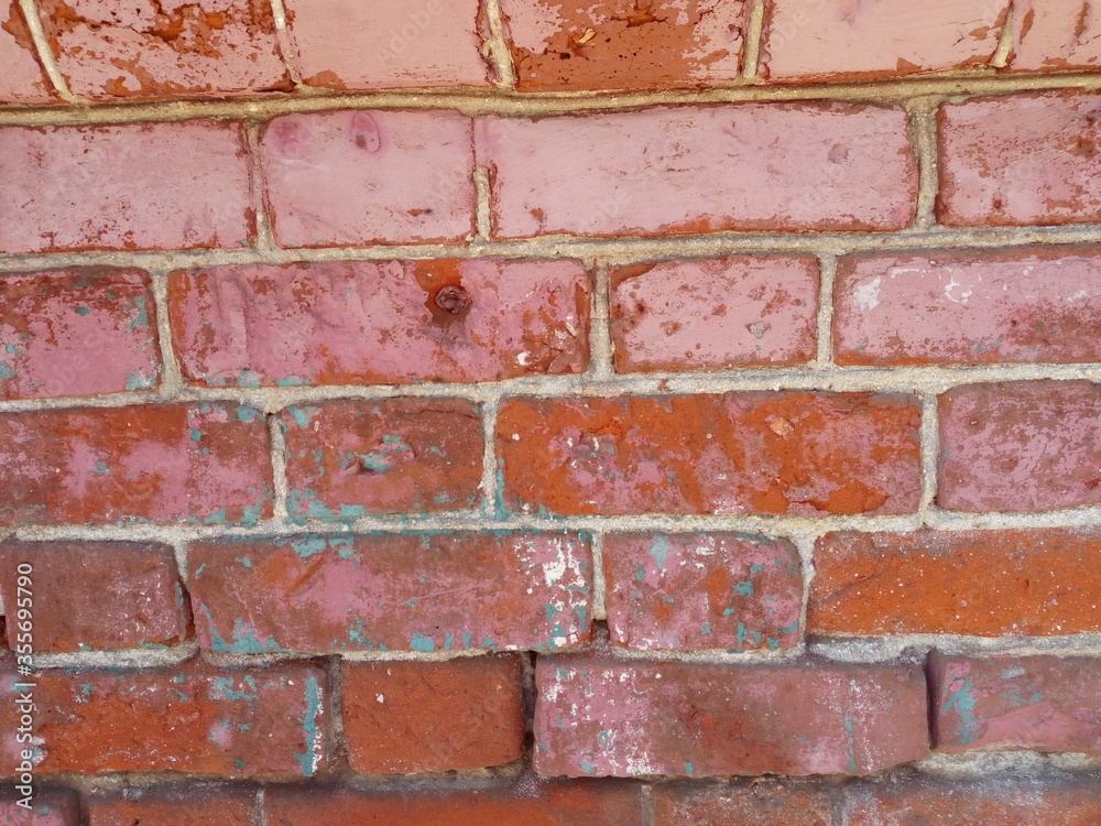 Brick wall. Red brick painted with front beige paint. Paint is missing in some places. Looks through the structure of the brick and cement mortar. Brick wall. Red brick painted with front beige paint. Paint is missing in some places. Looks through the structure of the brick and cement mortar.