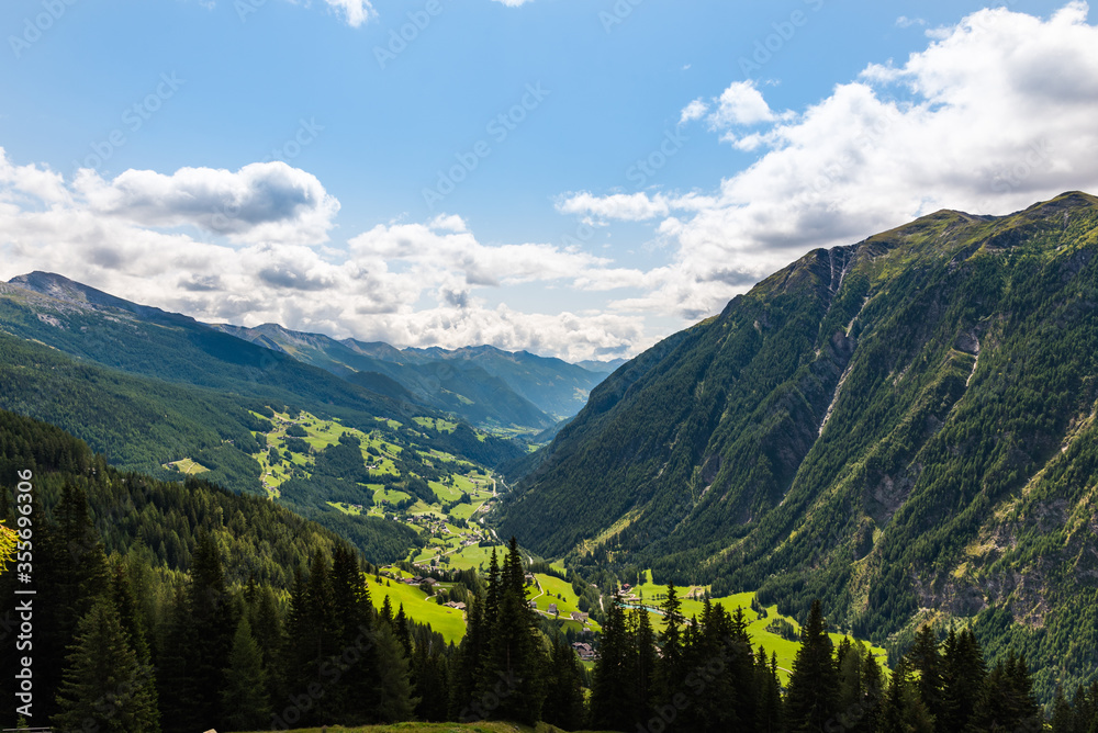 Green valley in Austrian Alps between mountains covered with forest
