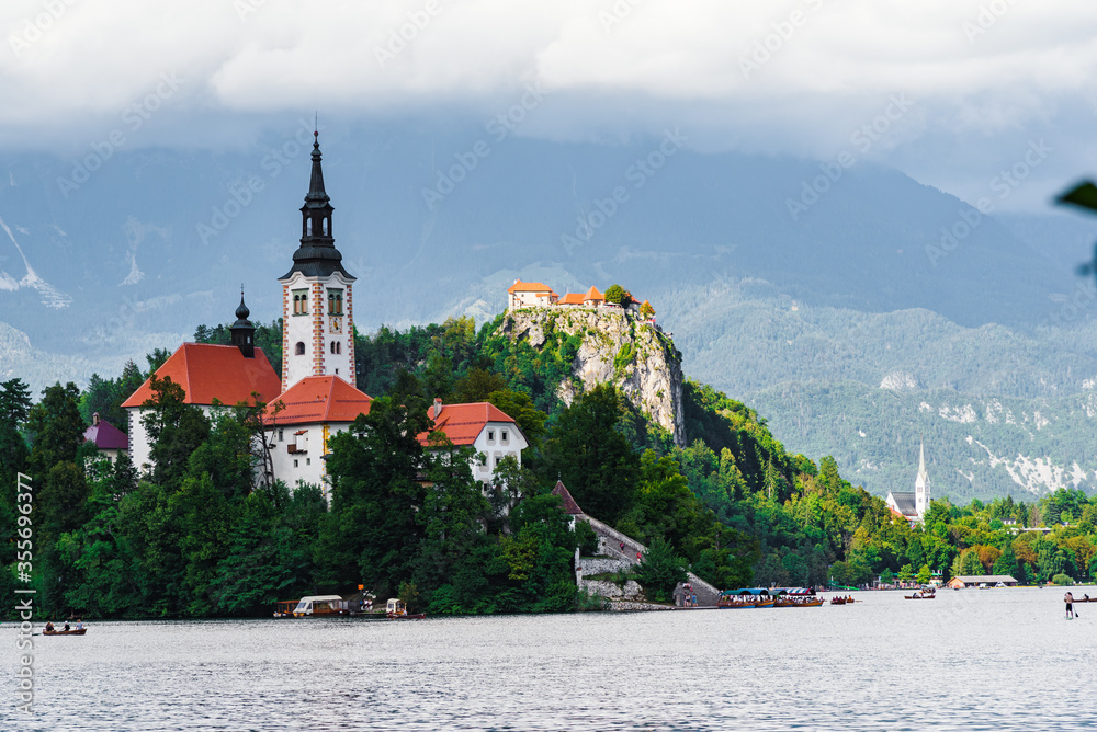 Beautiful cathedral in the middle of the lake surrounded by colourful trees Beautiful cathedral in the middle of the lake surrounded by colourful trees