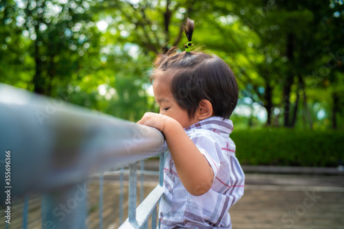 Little asian boy walking in city public green park