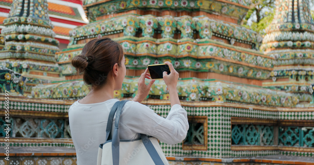 Woman take photo on cellphone at Thailand temple