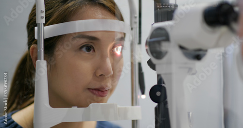 Woman checks her eyes in clinic