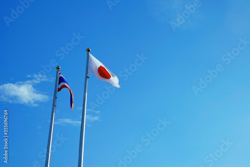 Thai flag and Japanese flag Blown by the wind with blue sky on background  