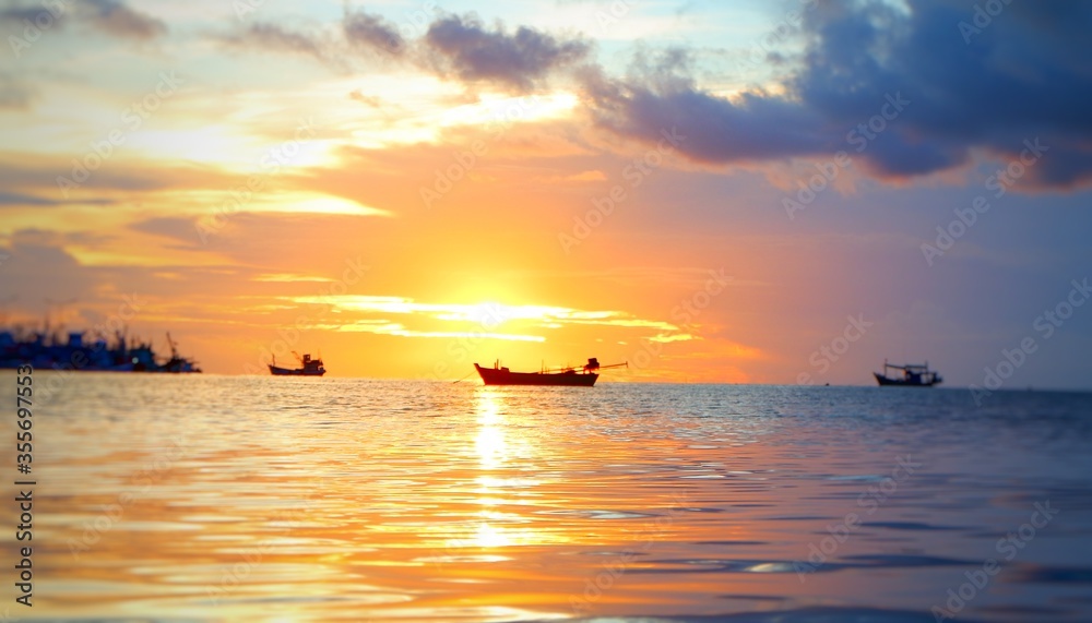 A fishing boat floats on the sea at sunset as a beautiful evening sea image. A fishing boat floats on the sea at sunset as a beautiful evening sea image.