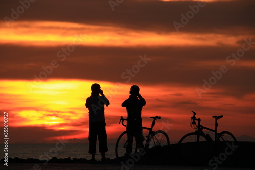 silhouette of a couple on bicycles at sunrise