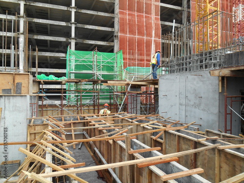 MALACCA, MALAYSIA -JULY 12, 2016: Construction workers fabricating timber form work at the construction site in Malacca, Malaysia. The form work was mainly made from timber and plywood. 