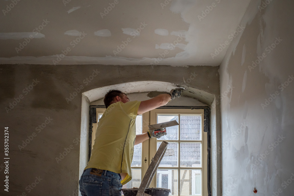  craftsman plastering a lintel with mortar on a building site.