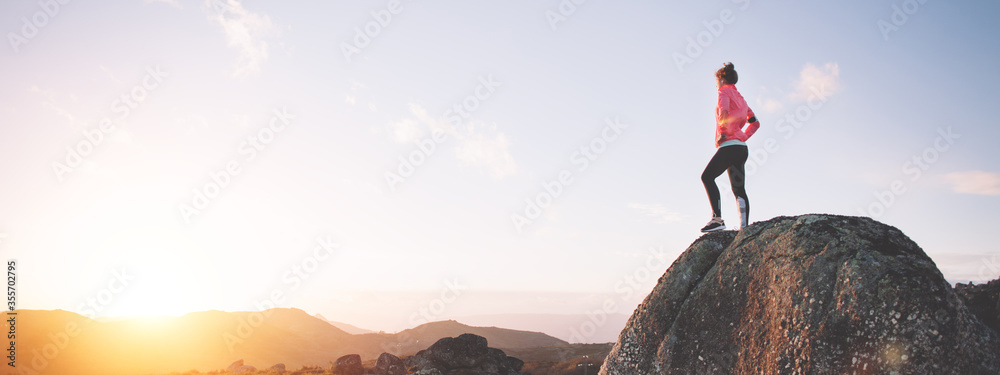 Athletic woman resting during training watching the sunset and mountain landscape. Sport tight clothes. - obrazy, fototapety, plakaty 