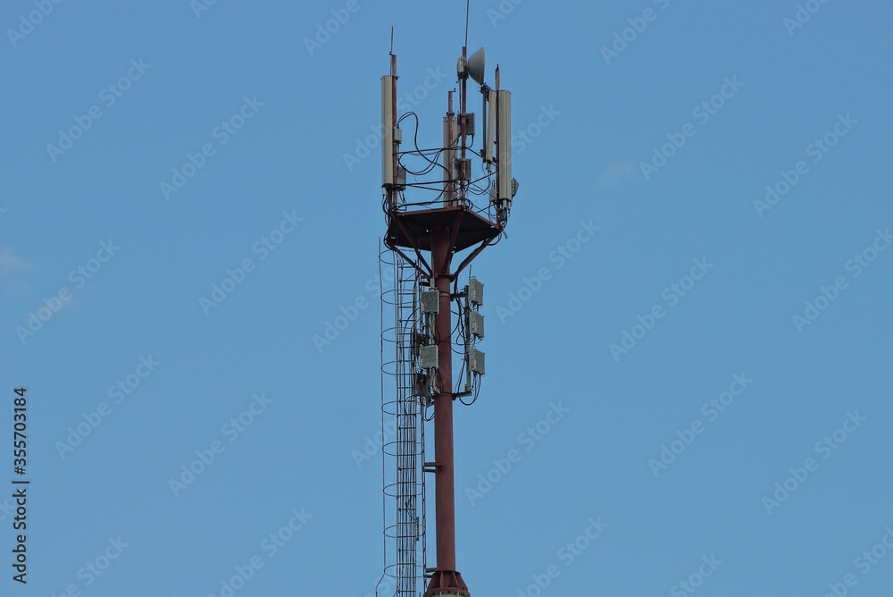 many antennas and translators on an iron pole against a blue sky many antennas and translators on an iron pole against a blue sky