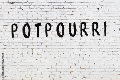 Word potpourri painted on white brick wall photo